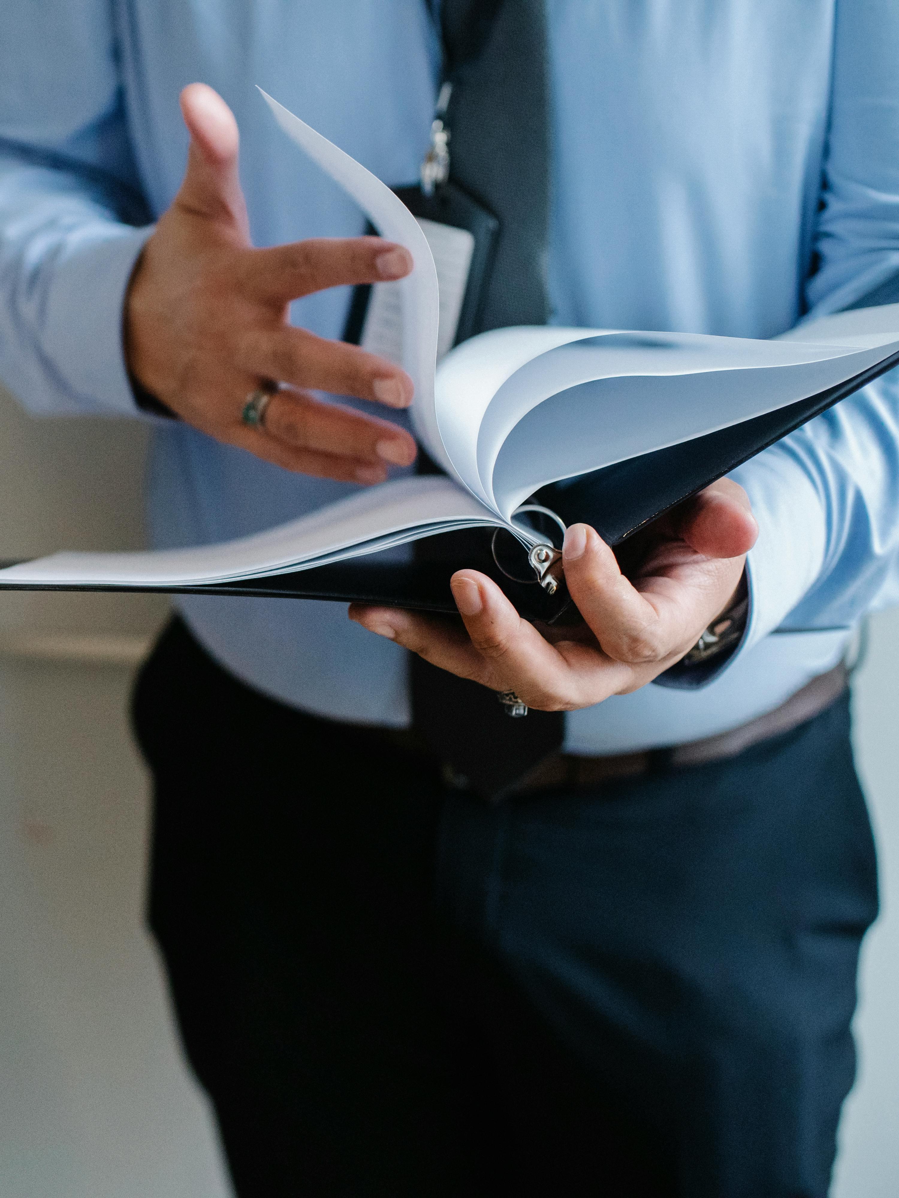 Hands reviewing a structured document binder